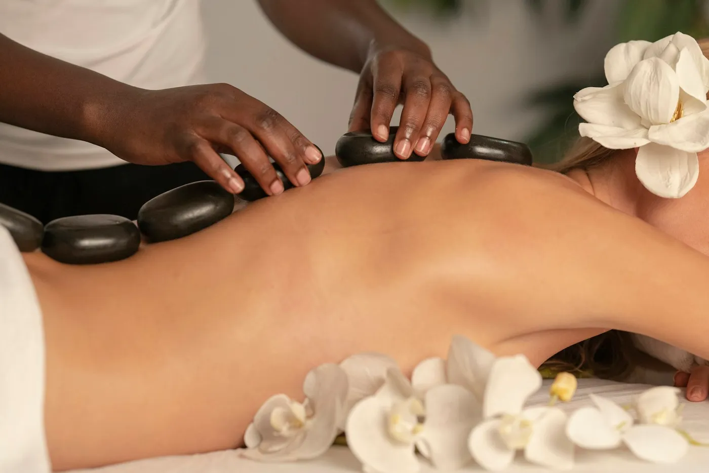 Therapist placing hot stones along the back during a massage